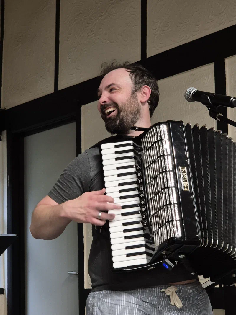 Dom laughing while playing the accordion