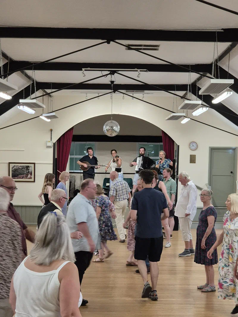 Dancers lined up in a bright village hall