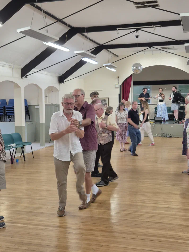 Couples dancing in a village hall