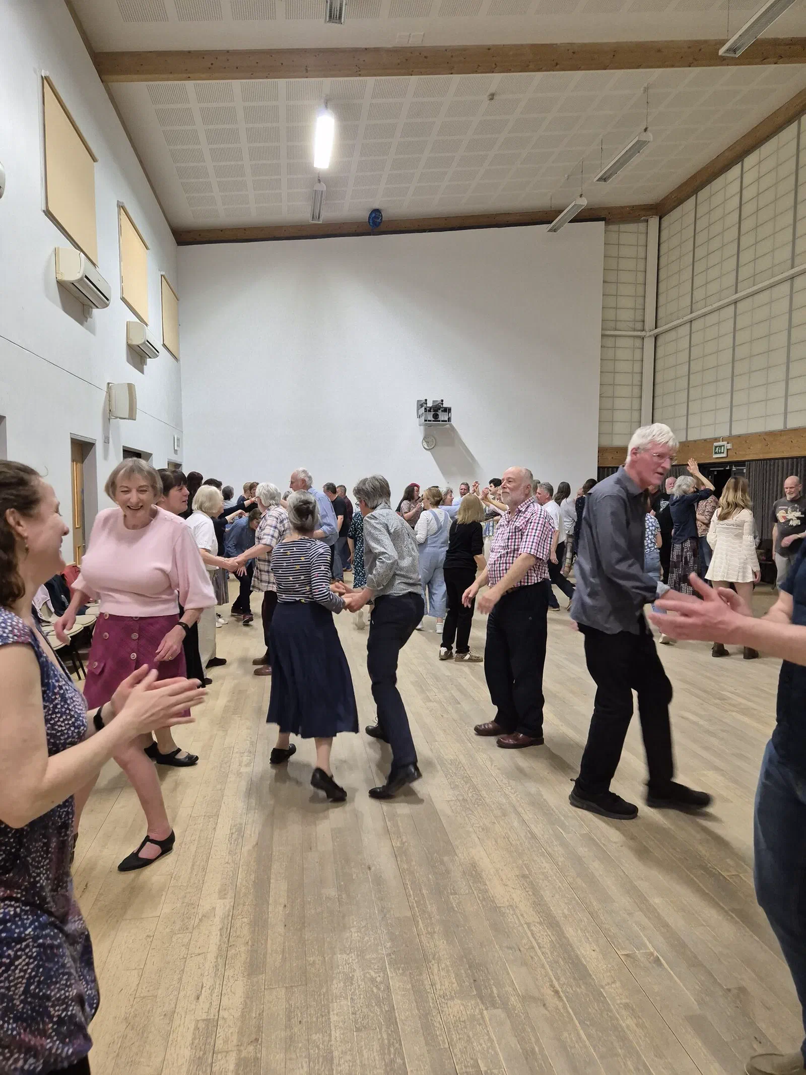 Dancers clapping in a circle at a village hall