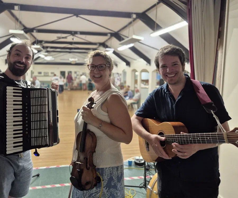 The band playing in a village hall with dancers on the floor